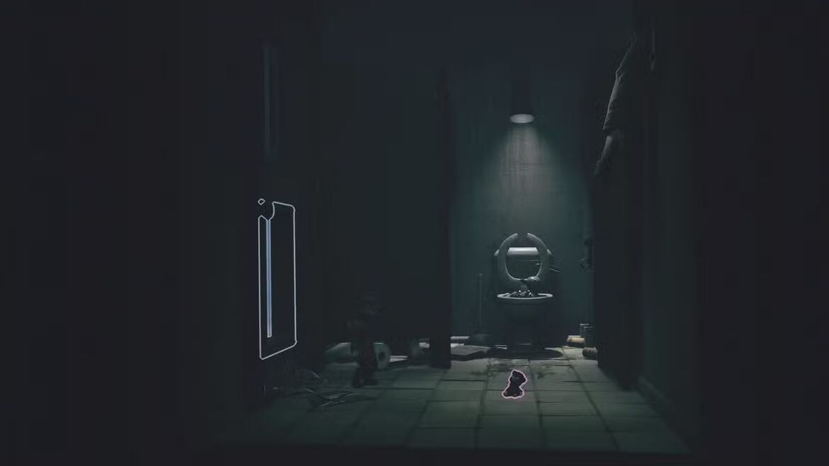 Алон собирает куклу с пола в ванной в Little Nightmares
