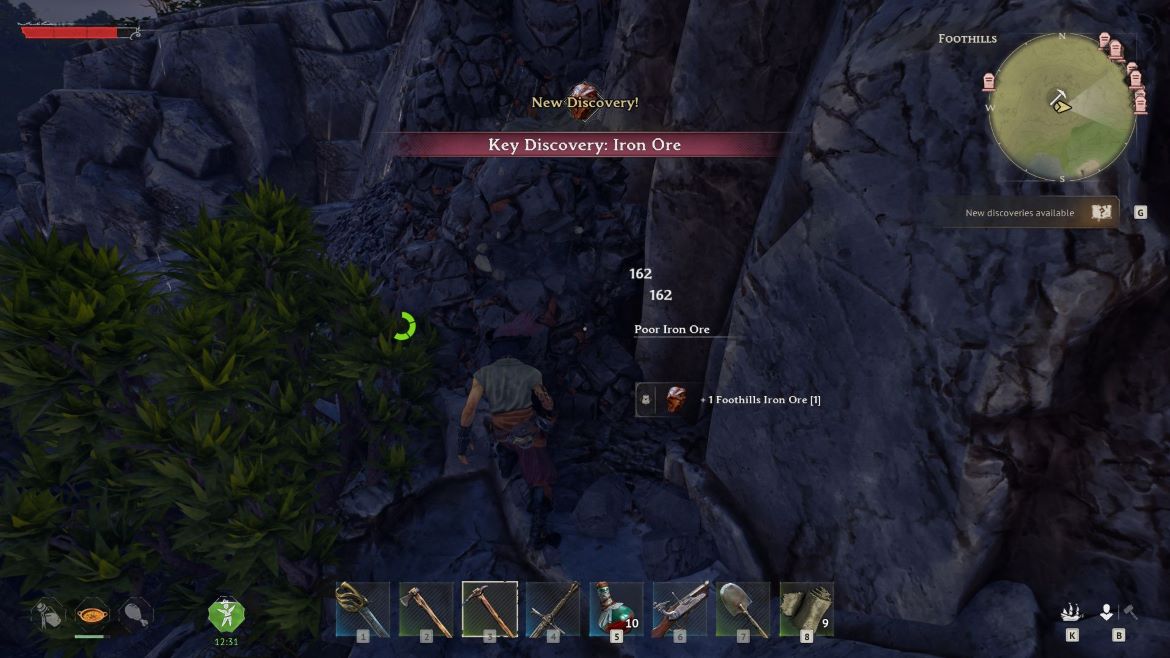 Player character in a rocky cave discovers iron ore with on screen prompts and a bottom inventory bar