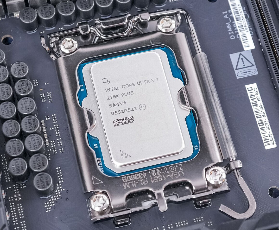 Close up of an Intel Core Ultra 7 processor mounted in an LGA socket on a motherboard with the metal retention frame and a blue protective surround visible The CPU label shows Intel Core Ultra 7 Z70K Plus and other markings