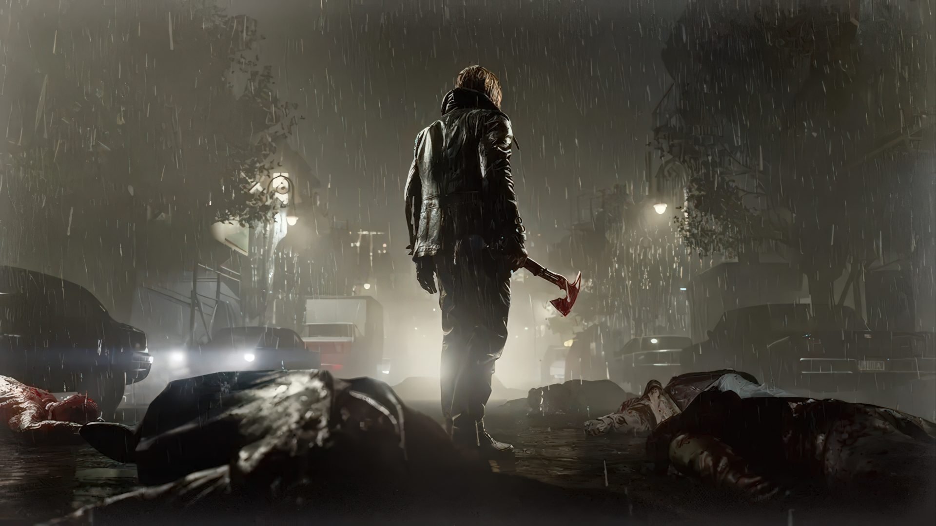 Man in a dark rain soaked city wears a hooded jacket and grips a blood stained axe standing amid debris and fallen bodies at night amid car headlights and streetlights