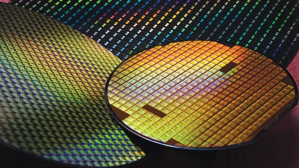Close up of a gold toned computer processor die with a grid of tiny squares reflecting rainbow colors