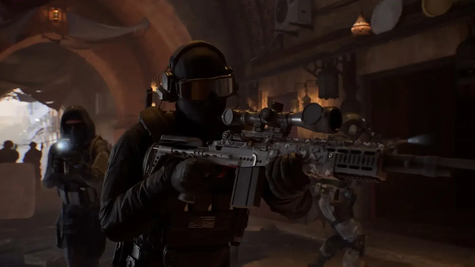 Tactical operator in black armor aims a sniper rifle with a scope in a dim indoor corridor with teammates in the background