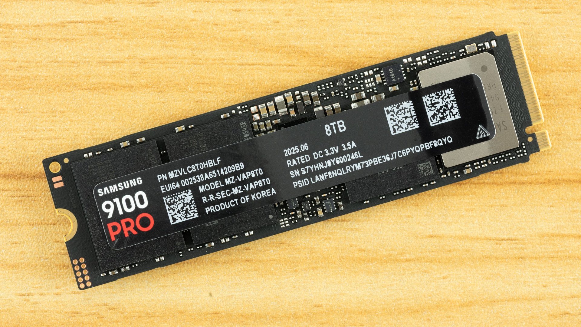 Samsung 9100 Pro 8TB NVMe SSD module on a wooden surface