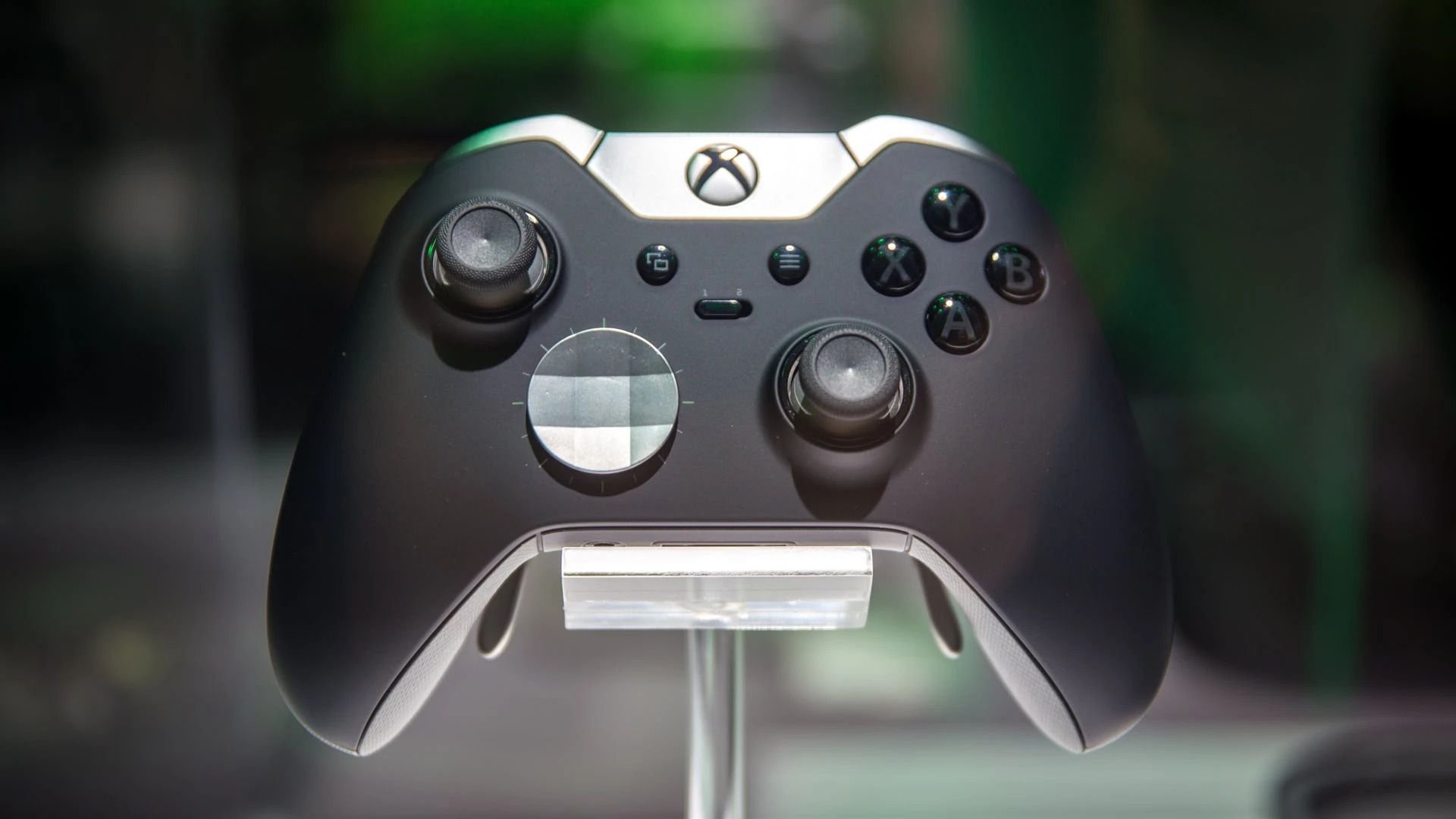 Close up of a black Xbox wireless controller on a display stand showing dual thumbsticks and labeled A B X Y buttons
