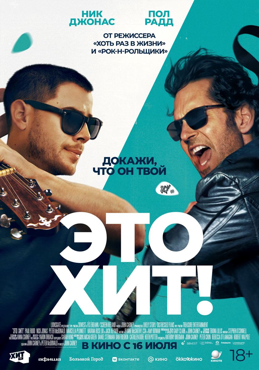 Постер фильма'Это хит!' с двумя мужчинами в очках на синей/бирюзовой разбивке фона, крупная надпись 'ЭТО ХИТ!' снизу и текст 'Докажи, что он твой' между ними.