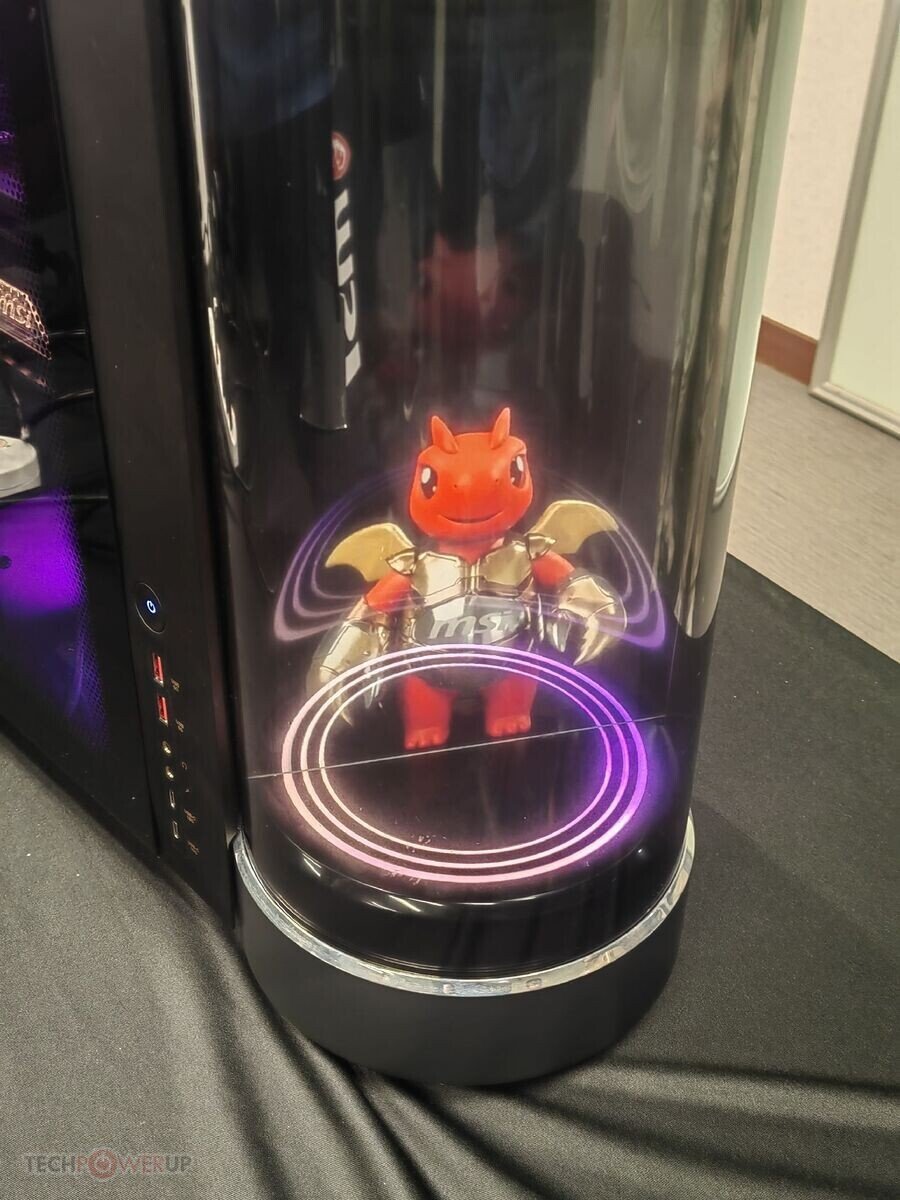 Red dragon figurine with gold wings inside a glossy black computer tower illuminated by purple circular lights at the base