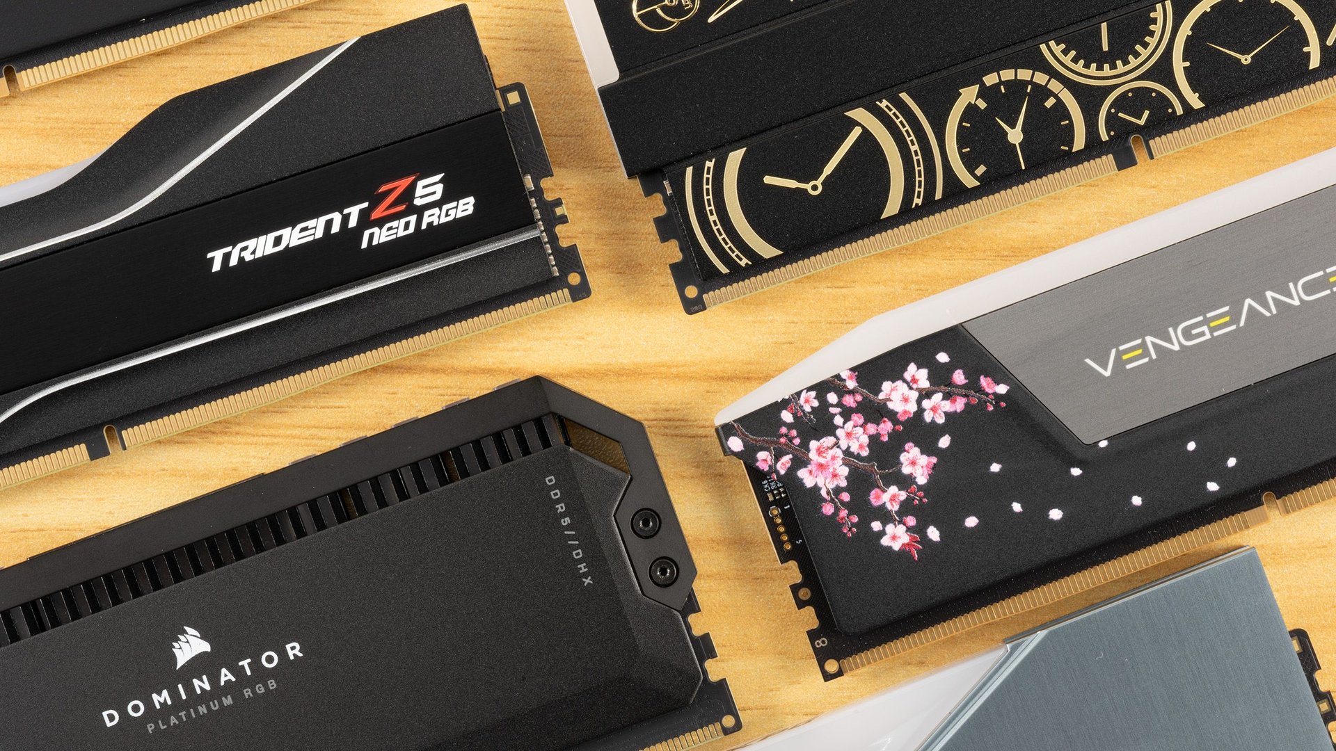 Assortment of RGB RAM sticks laid on a wooden surface showing brands like Corsair Dominator Platinum RGB GSkill Trident Z5 Neo RGB and Corsair Vengeance