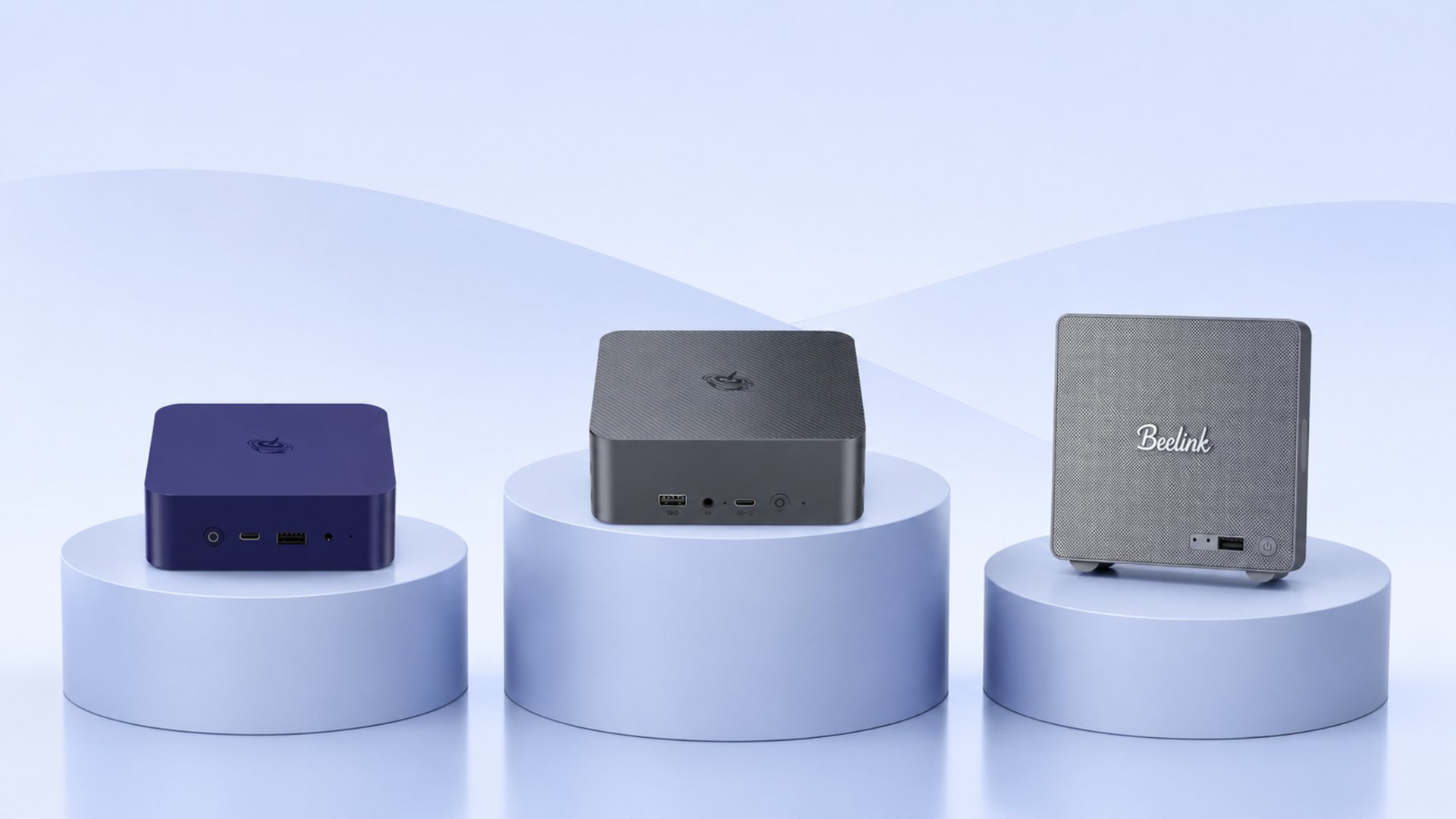 Three compact mini PCs displayed on light blue pedestals against a pale gradient backdrop