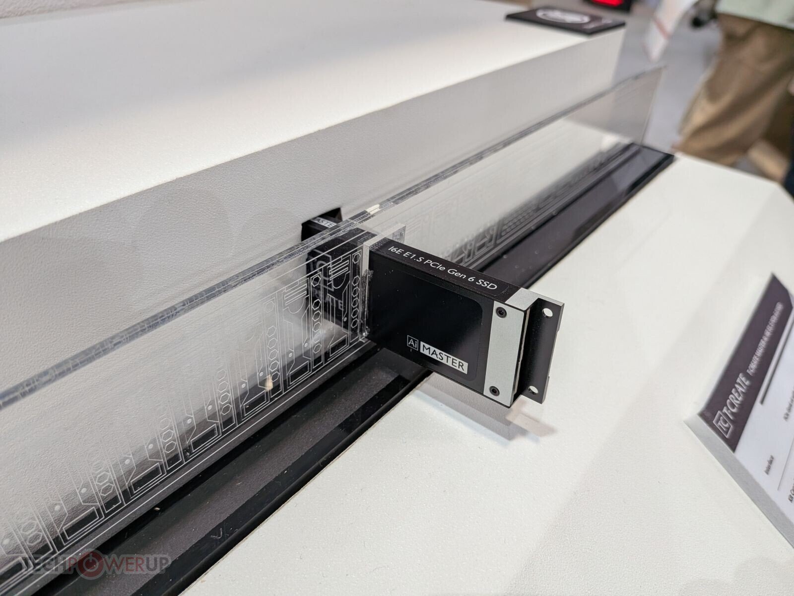 Close up of a PCIe Gen 6 NVMe SSD in a black carrier module labeled AI Master plugged into a testing rack
