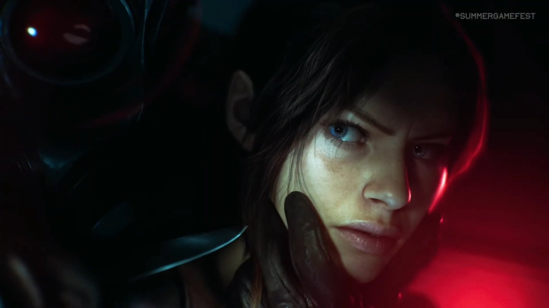 Close up of a woman with a blue eye in a dark setting red edge lighting and a gloved hand near her face