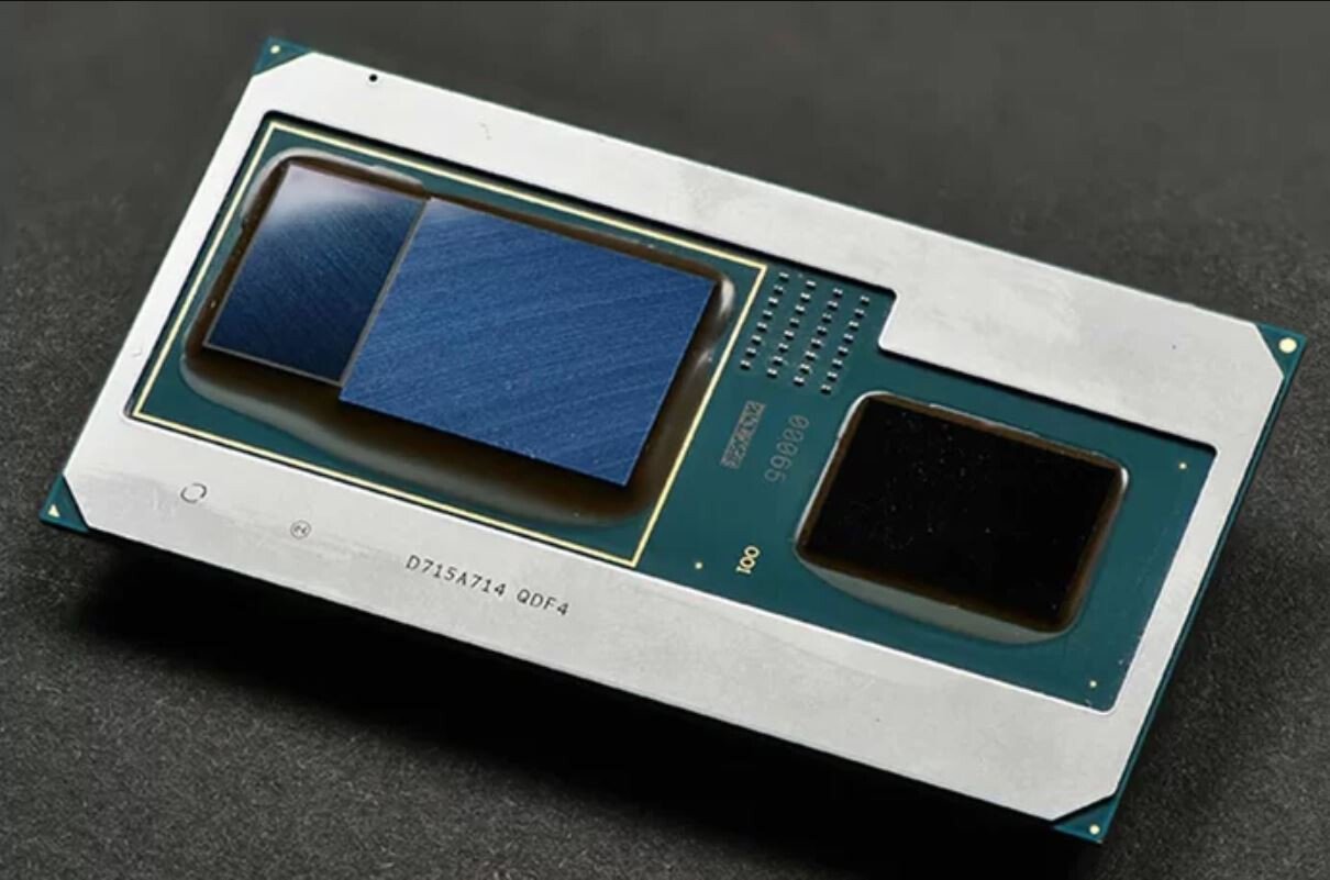 Dual die computer processor on a metal carrier with blue heat spreader pads and a green substrate on a dark surface