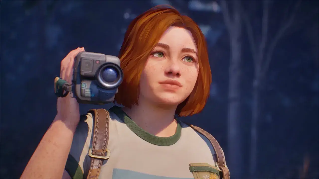 Young woman with short red hair holds a handheld video camera to her shoulder standing in a forest at dusk