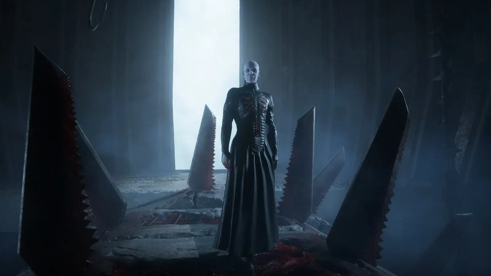 Eerie humanoid figure in a dark robe stands in a cavernous chamber with tall jagged pillars and a pale blue light behind them foreboding atmosphere