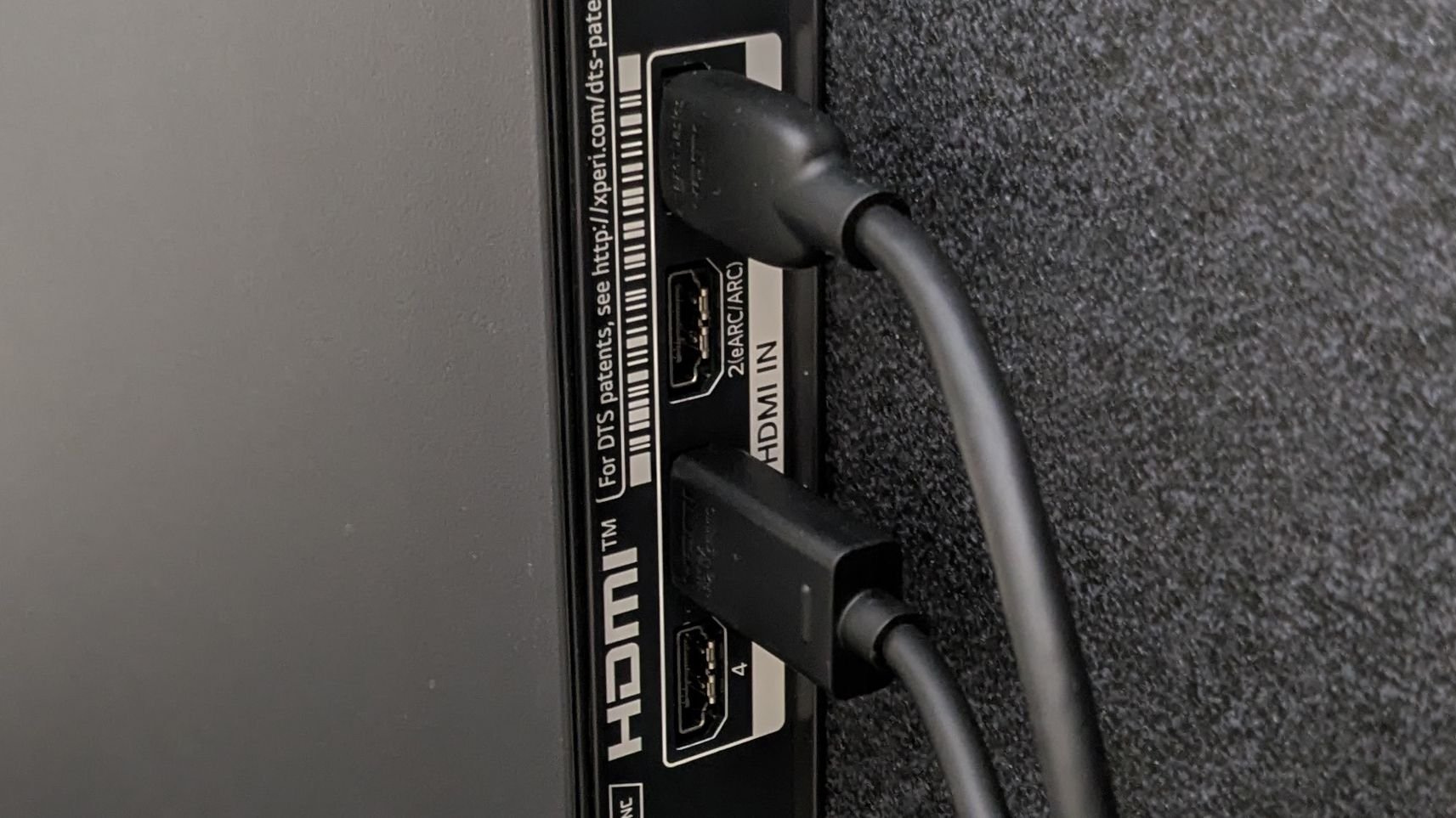 Two HDMI cables connected to the HDMI IN ports on the back of a black electronic device