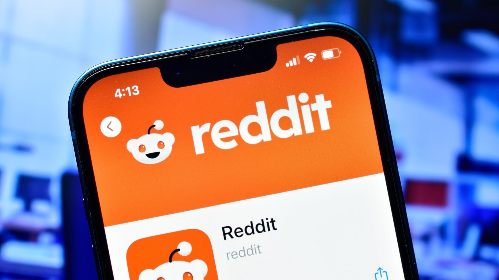 Smartphone screen displaying the Reddit app header in orange with logo on top of a list view