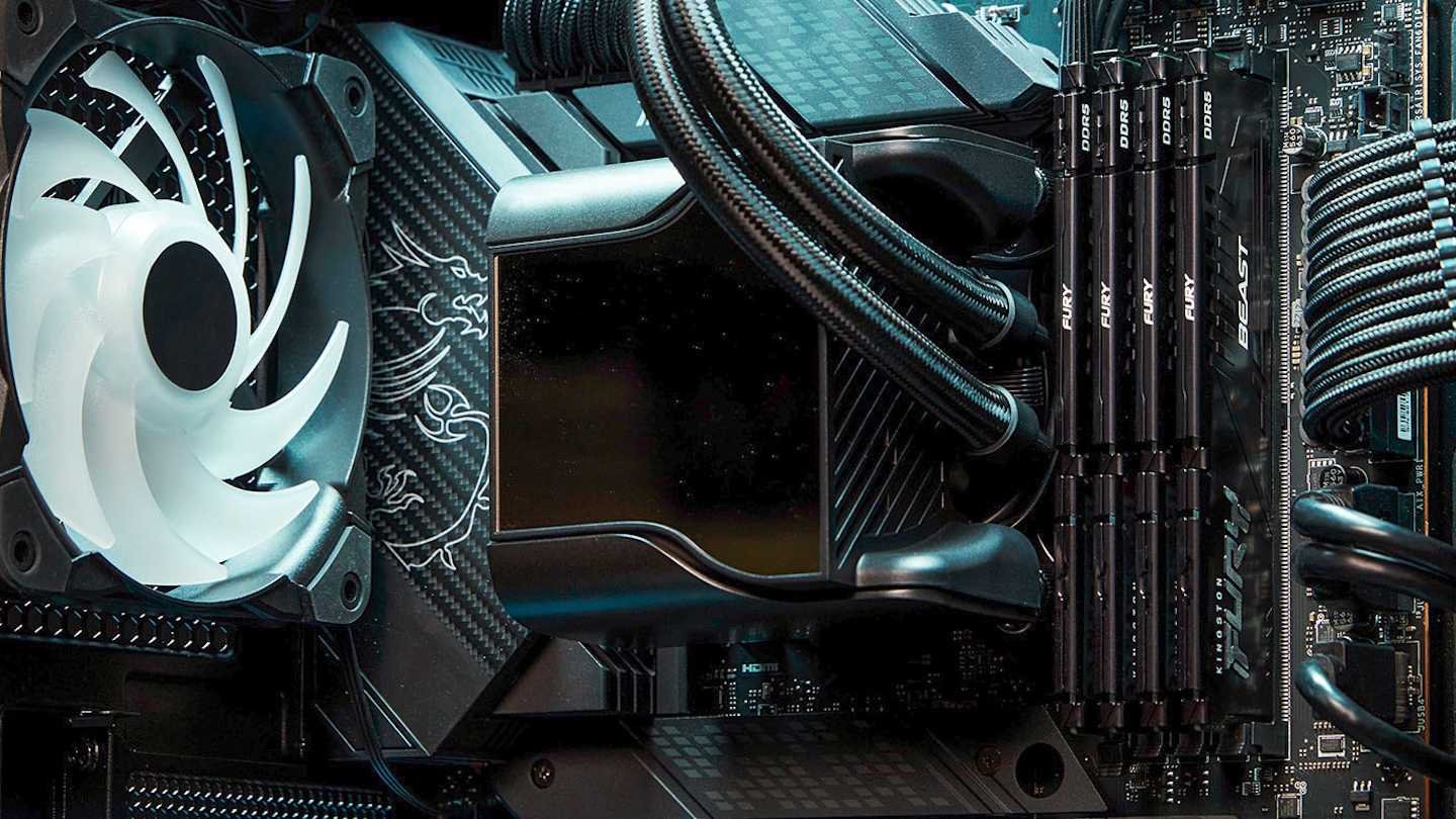 Close up of a desktop PC internals white case fan liquid cooling tubes RAM sticks labeled FURY and a motherboard surface by the block cooling area