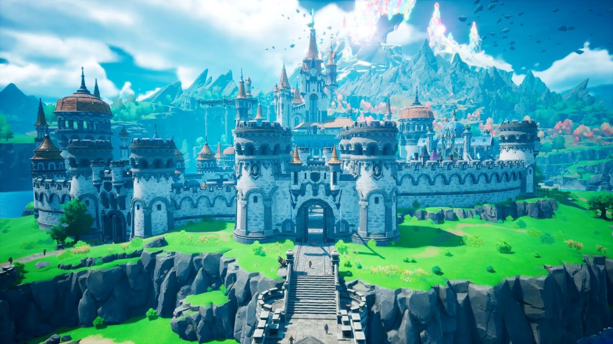 Stone castle with multiple towers on a grassy cliff connected by a bridge with mountains in the distance