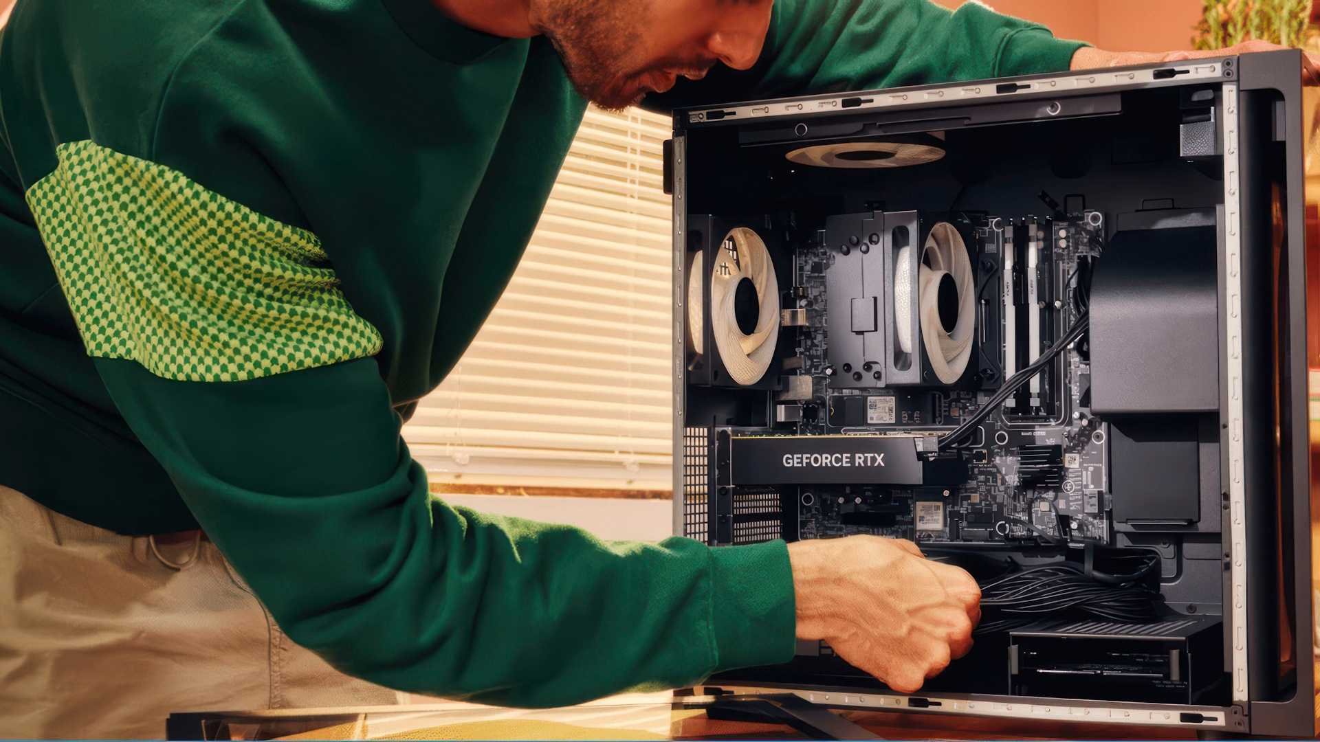 Person in a green shirt works inside a desktop computer case with a GeForce RTX graphics card visible