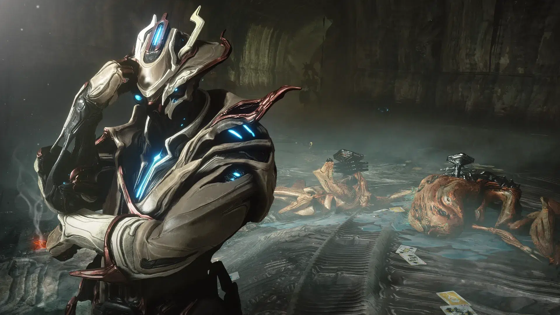 Futuristic armored warrior with glowing blue accents kneels in a dark ruined chamber touching their helmet amid fallen alien figures and scattered debris