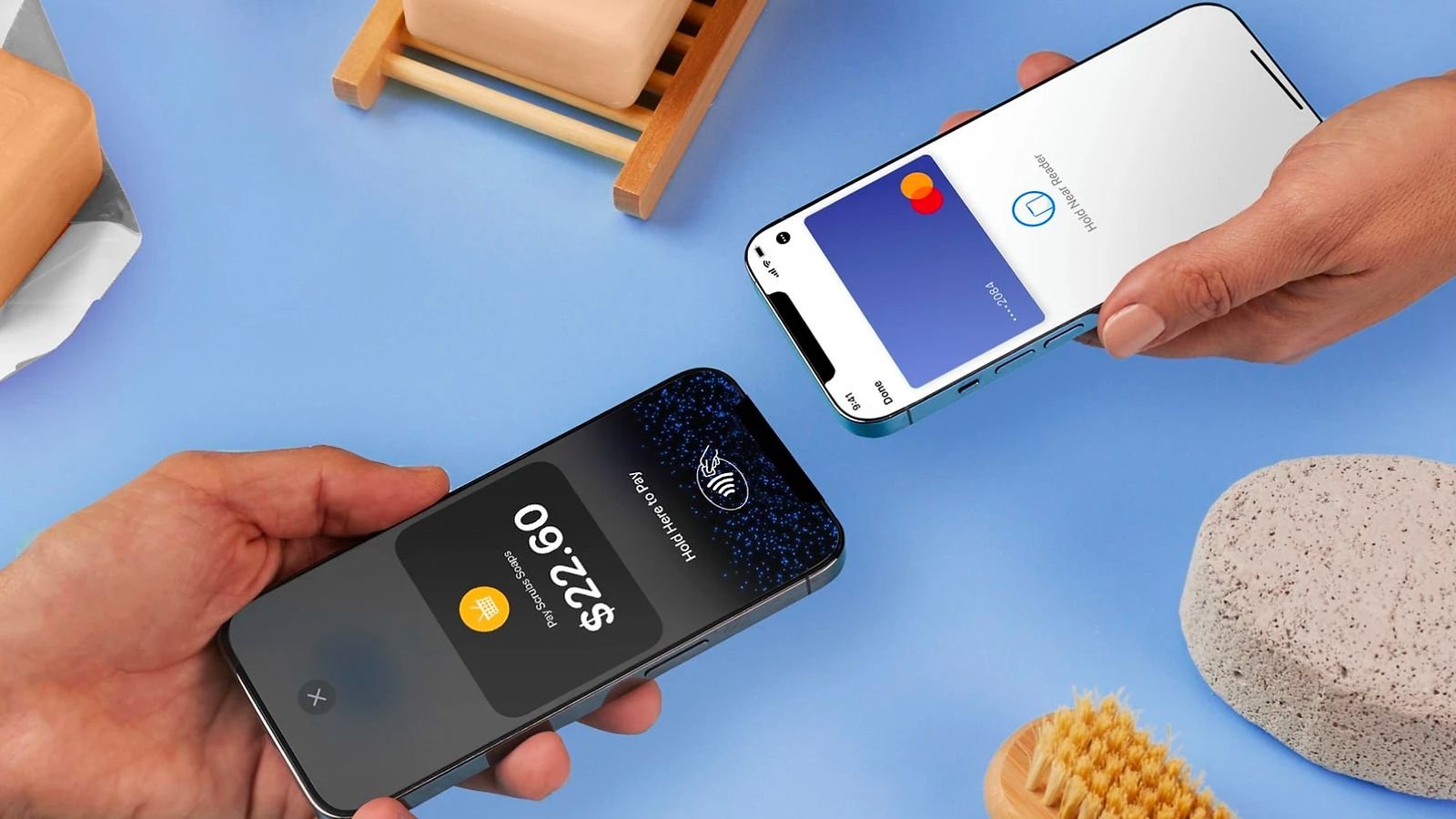 Two hands holding smartphones showing digital wallet payment screens Mastercard and wallet app on a blue surface