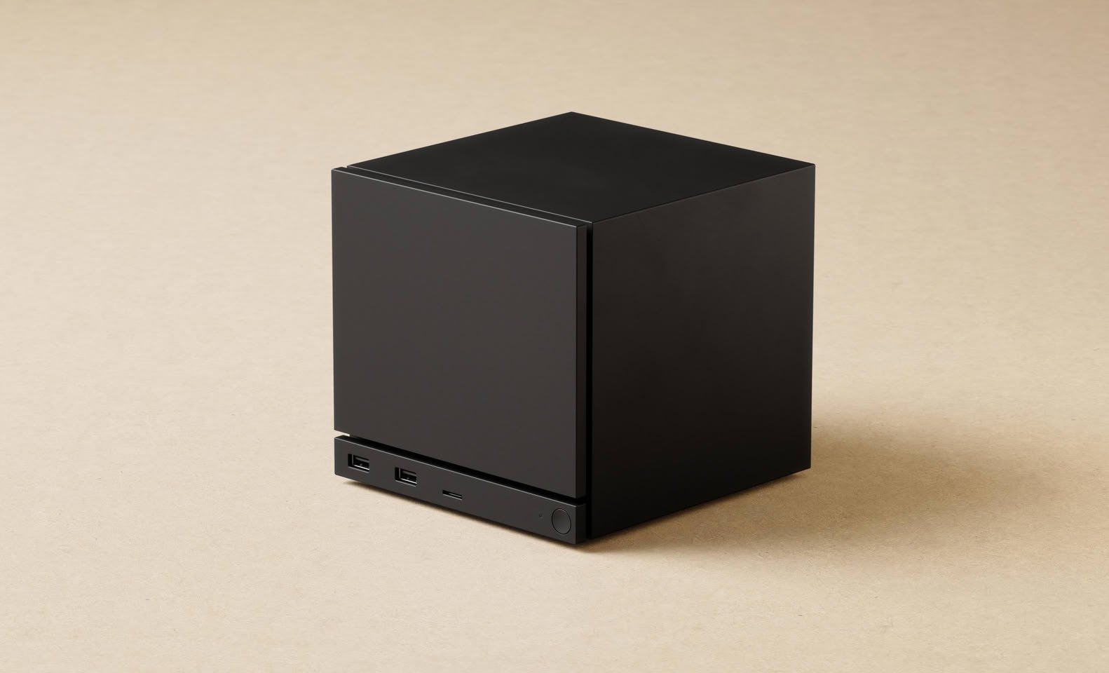 Black cube shaped desktop computer or NASserver with two USB ports on the front panel against a beige background
