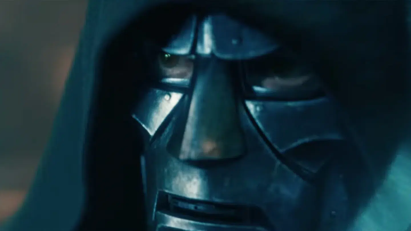 Close up of a black metallic helmet with visor and breathing grills under blue lighting hooded figure present