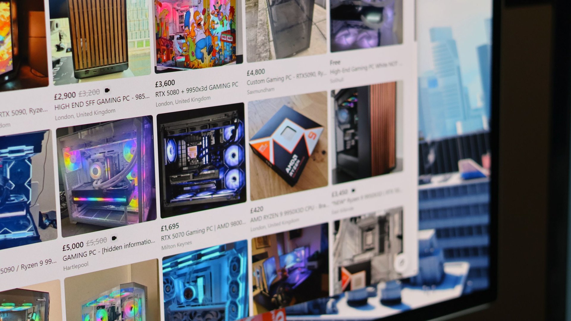 Grid of PC gaming desktops and components for sale on an online marketplace with prices visible on a monitor screen